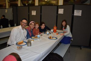 Happy Family Eating Dinner at Chanuka Party